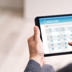 Male Looking At Calendar On Tablet Computer